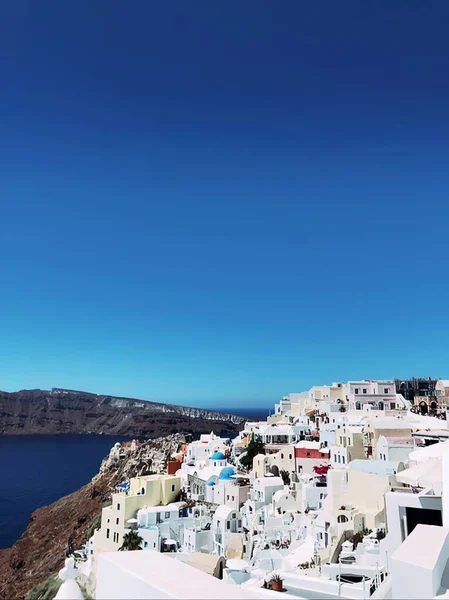 在希腊圣托里尼火山岛上 爱琴海 美丽的欧亚镇尽收眼底 具有蓝色圆顶 屋顶和明亮白色墙壁的传统而著名的房屋和教堂 图库照片