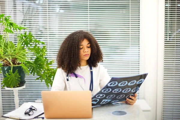 Retrato Médico Feminino Étnico Analisando Raio Ressonância Magnética Enquanto Trabalhava Imagem De Stock