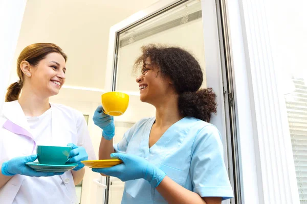 Two Happy Multi Ethnic Female Medical Workers Colleagues Drinking Coffee — Stock Photo, Image