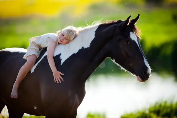 Παιδί κάθεται σε ένα άλογο Royalty Free Εικόνες Αρχείου