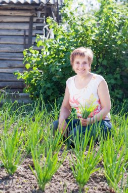 kadın onu bahçede genç soğan bir demet ile