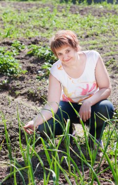 kadın onu bahçede genç soğan bir demet ile