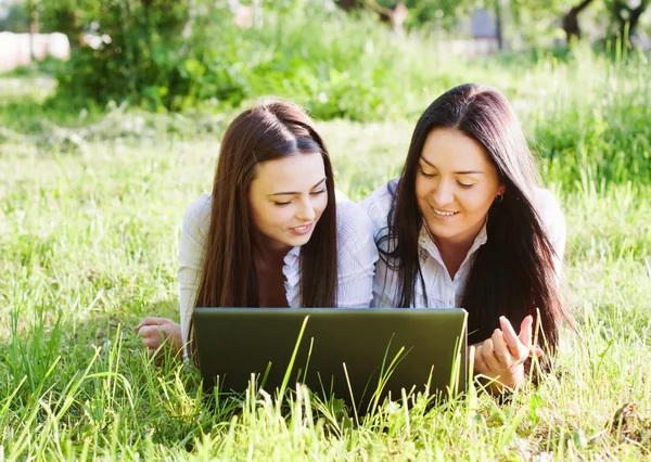 Två tjejer med laptop utomhus — Stockfoto