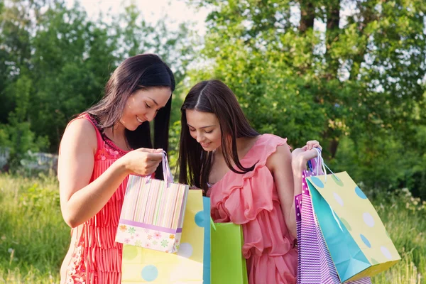 Twee meisjes met gekleurde zakken buiten — Stockfoto