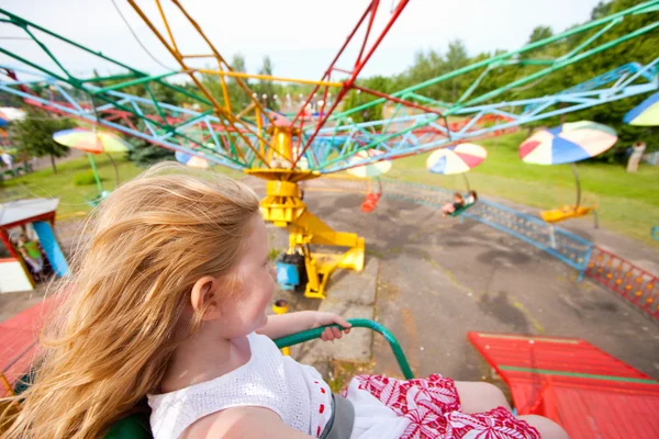 Little girl having fun in a carousel — Stock Photo, Image