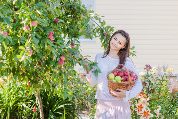 Beautiful girl with apple in garden