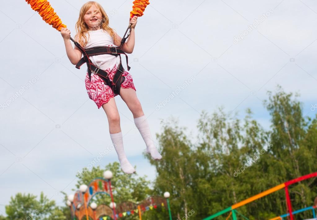 Happy girl jumping in amusement park