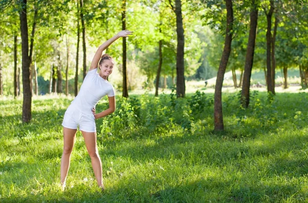 Piękna młoda kobieta robi ćwiczenia rozciągające — Zdjęcie stockowe