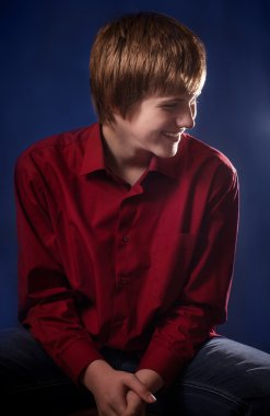 oğlan mavi arka plan üzerinde gülümseyen