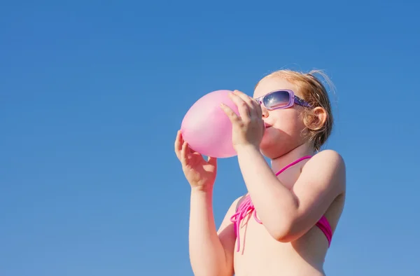 Menina inflando balão — Fotografia de Stock