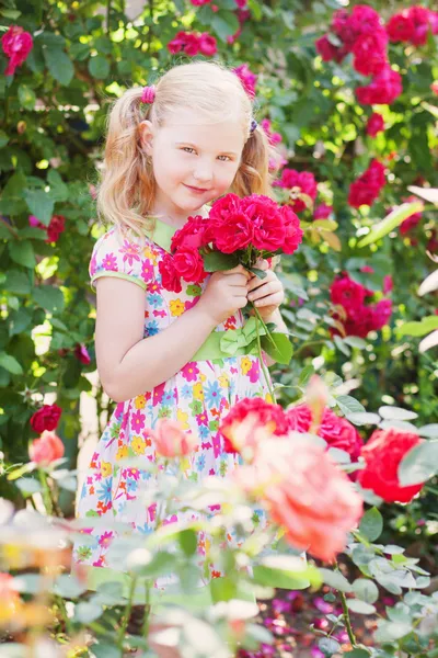 Šťastná dívka s růží v zahradě — Stock fotografie