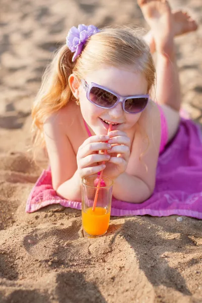 Little girl drinks orange juice outdoor — Stock Photo, Image