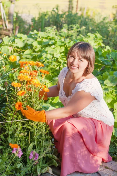 屋外の花を持つ女性を笑顔します。 — ストック写真