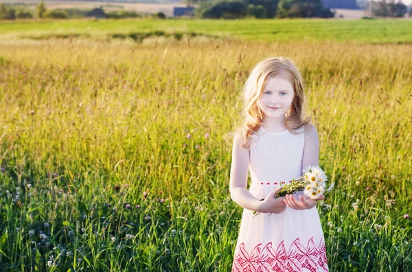 Mooi meisje met bloemen buiten — Stockfoto
