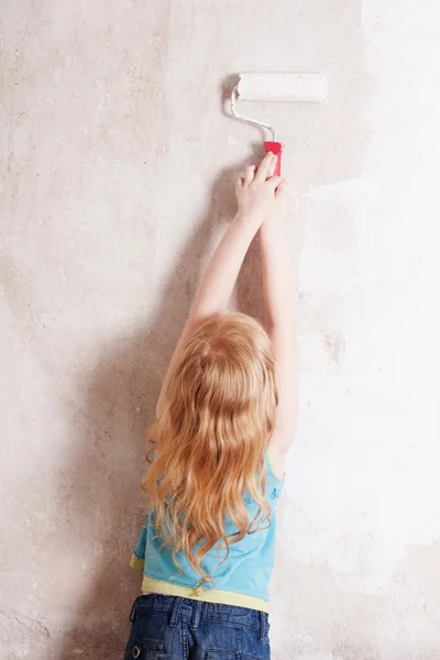 Улыбающаяся девушка, рисующая стену — стоковое фото