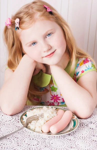 Girl with a bowl of rice porridge and sausage — Stock Photo, Image