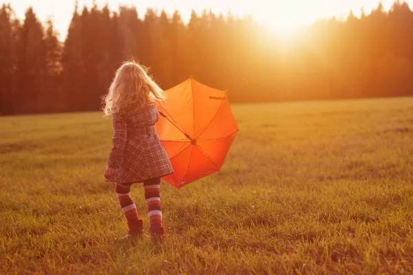 Menina com guarda-chuva no campo — Fotografia de Stock
