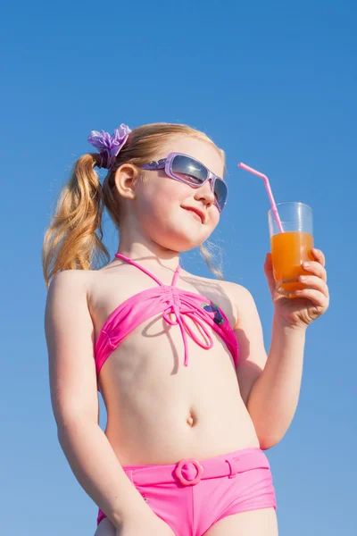 Little girl drinks orange juice outdoor — Stock Photo, Image