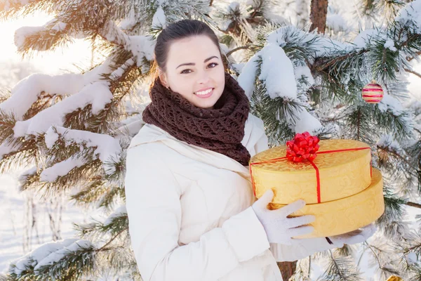 Meisje met cadeau in winter park — Stockfoto
