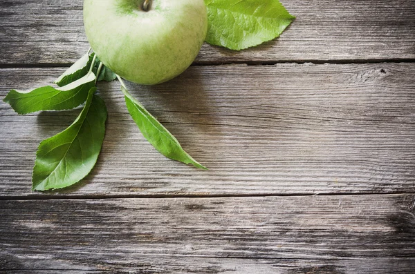 Grüner Apfel auf hölzernem Hintergrund — Stockfoto