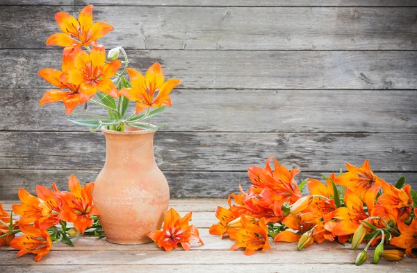 Oranžové lilie na dřevěné pozadí — Stock fotografie