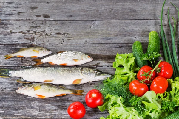 Riviervis met groenten op houten achtergrond — Stockfoto