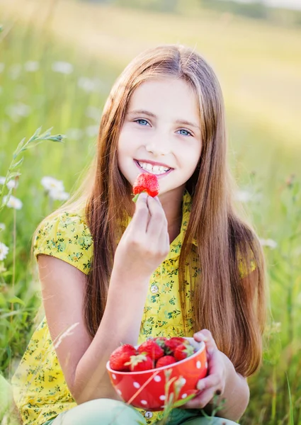 Gelukkig meisje met aardbei buiten — Stockfoto