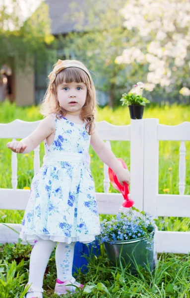 Girl watering spring flowers — Stock Photo, Image