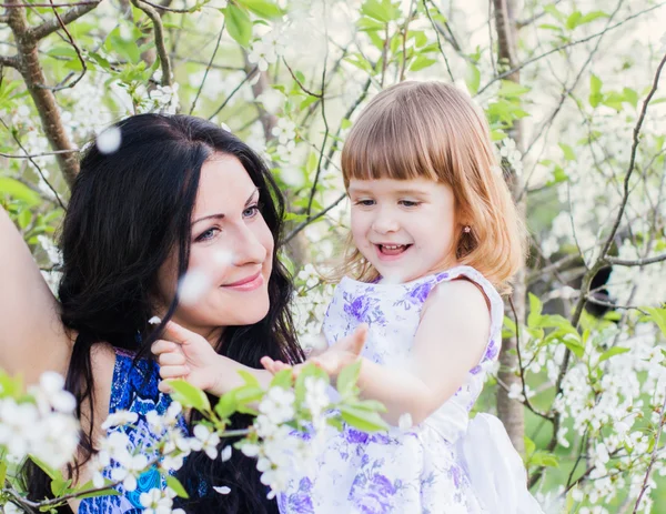 Madre feliz con niño en el jardín de primavera — Foto de Stock