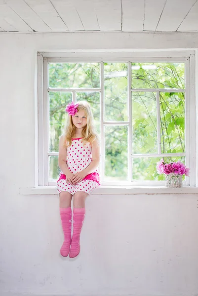 Little girl sitting on the window — Stock Photo, Image