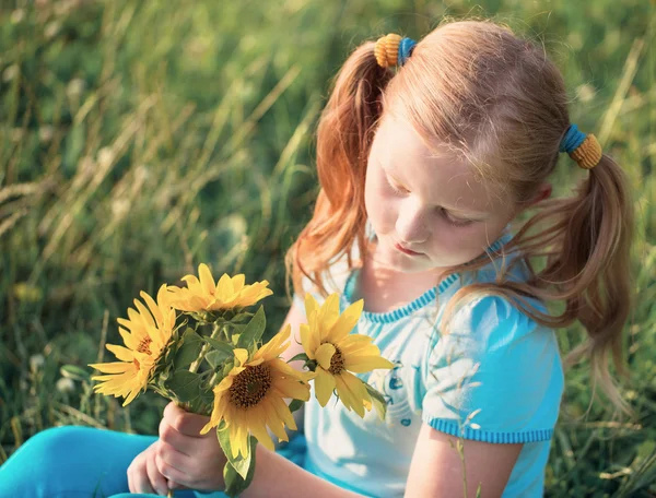 Маленька дівчинка з соняшниками — стокове фото