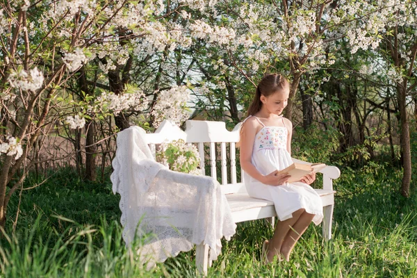 Menina com livro no jardim — Fotografia de Stock