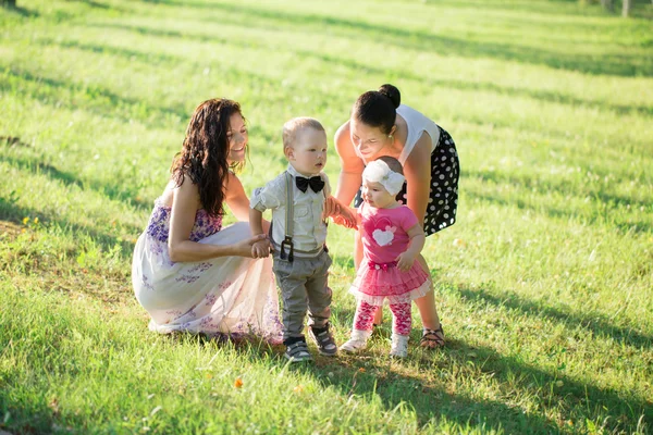 Two mothers with children in summer park — Stock Photo, Image