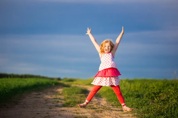 Feliz niña saltando delante del cielo azul —  Fotos de Stock