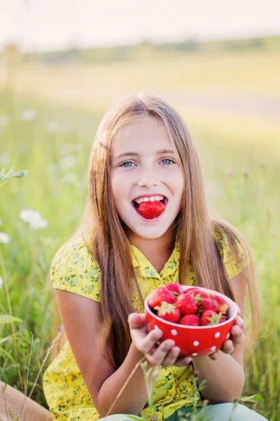Menina feliz com morango ao ar livre — Fotografia de Stock