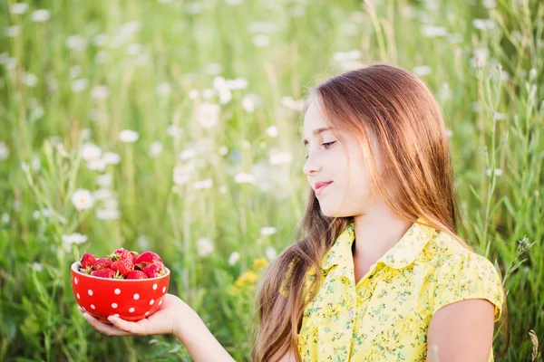 Счастливая девушка с клубникой на открытом воздухе — стоковое фото