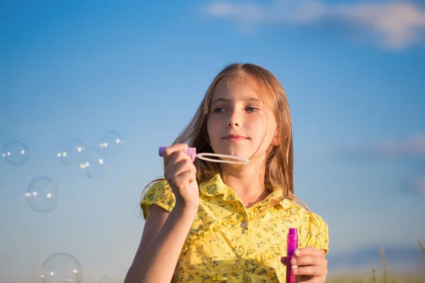 Счастливая девушка с мыльными пузырями — стоковое фото
