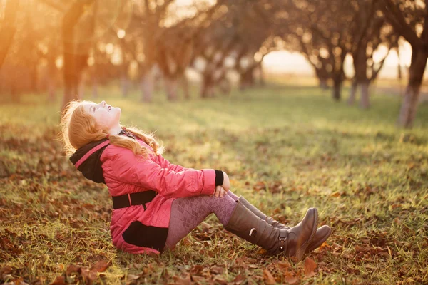 Gelukkig meisje op gras in de tuin — Stockfoto