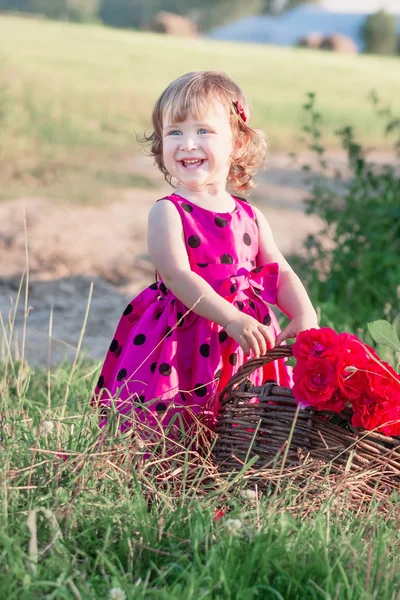 Lillle menina com flores ao ar livre — Fotografia de Stock