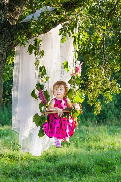 Happy little girl in swing outdoor — Stock Photo, Image