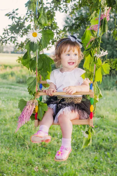 Cute little girl swinging at park — Stock Photo, Image
