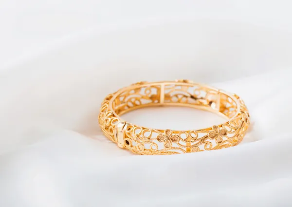 Gold bracelet on white cloth — Stock Photo, Image