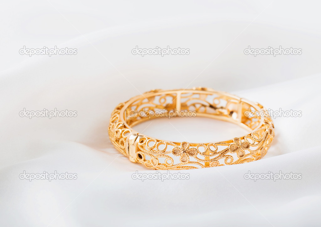 gold bracelet on white cloth