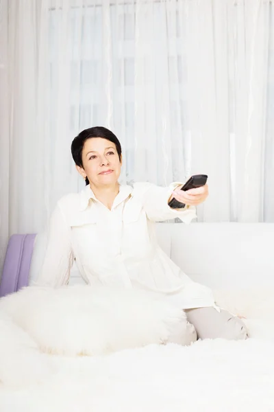 Mulher assistindo televisão enquanto deitado na cama — Fotografia de Stock