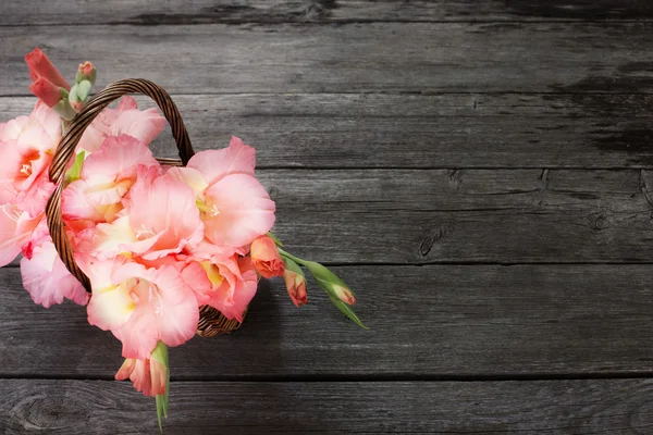 Blumen im Korb auf Holzgrund — Stockfoto