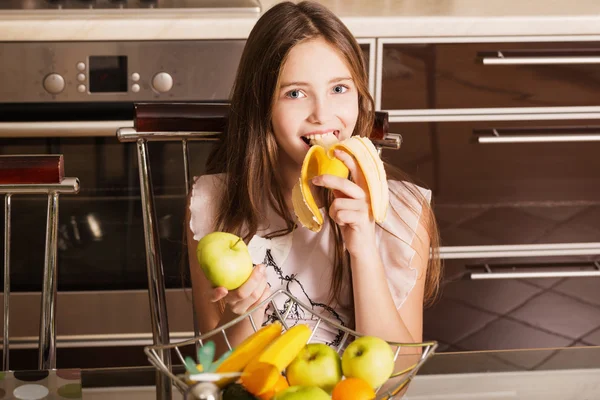 Sorriso menina com frutas na cozinha — Fotografia de Stock