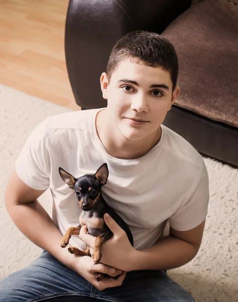 Adolescente com cão em casa — Fotografia de Stock