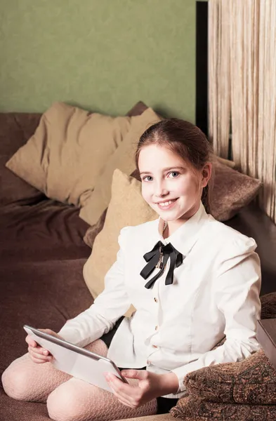 Menina pré-adolescente bonita com tablet pc interior — Fotografia de Stock