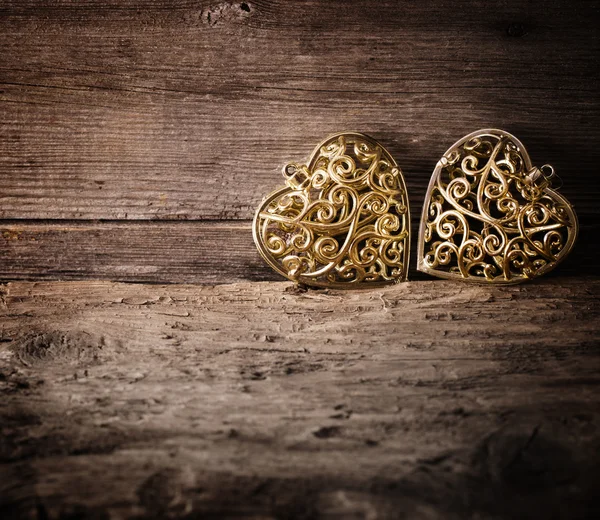 Coração dourado sobre fundo de madeira — Fotografia de Stock