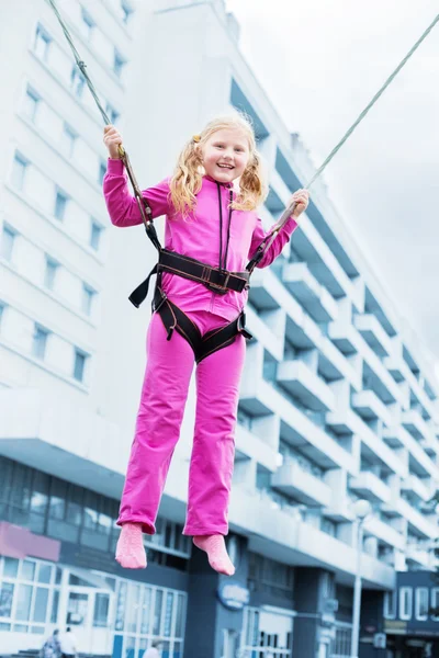 Happy girl jumping on background building — Stock Photo, Image